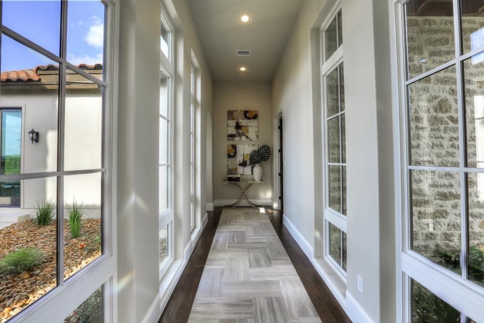 Hallway - mid-sized transitional dark wood floor hallway idea in Austin with gray walls