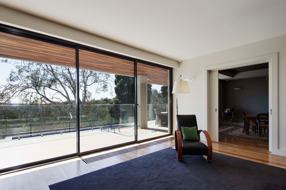 Photo of a large midcentury enclosed living room in Melbourne with white walls, light hardwood floors and no fireplace.