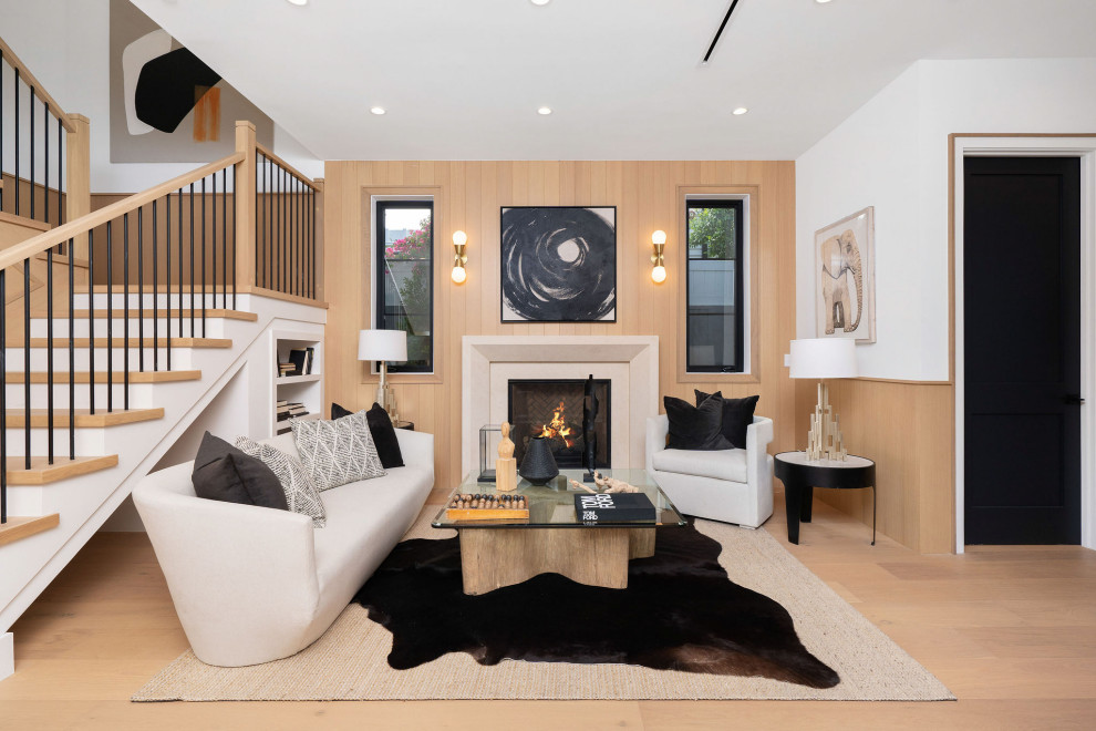Inspiration for a medium sized traditional open plan living room in Los Angeles with a standard fireplace, a stone fireplace surround, white walls, light hardwood flooring, beige floors and wood walls.