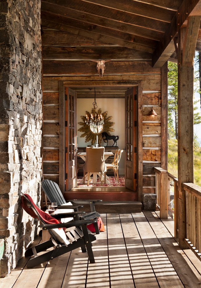 Example of a mountain style backyard deck design with a roof extension