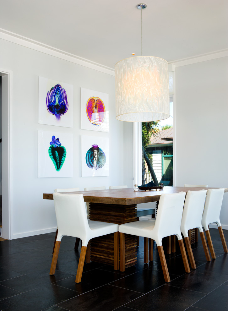 Photo of a beach style dining room in Charleston with white walls, no fireplace and black floor.