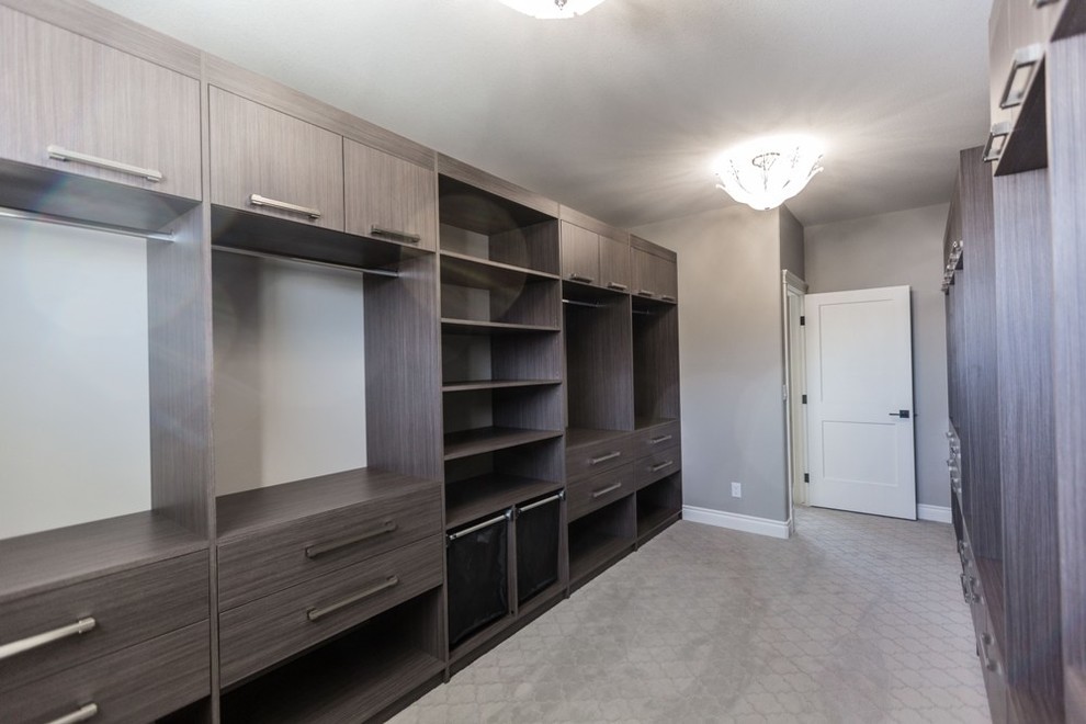 Expansive transitional gender-neutral walk-in wardrobe in Other with flat-panel cabinets, medium wood cabinets and carpet.