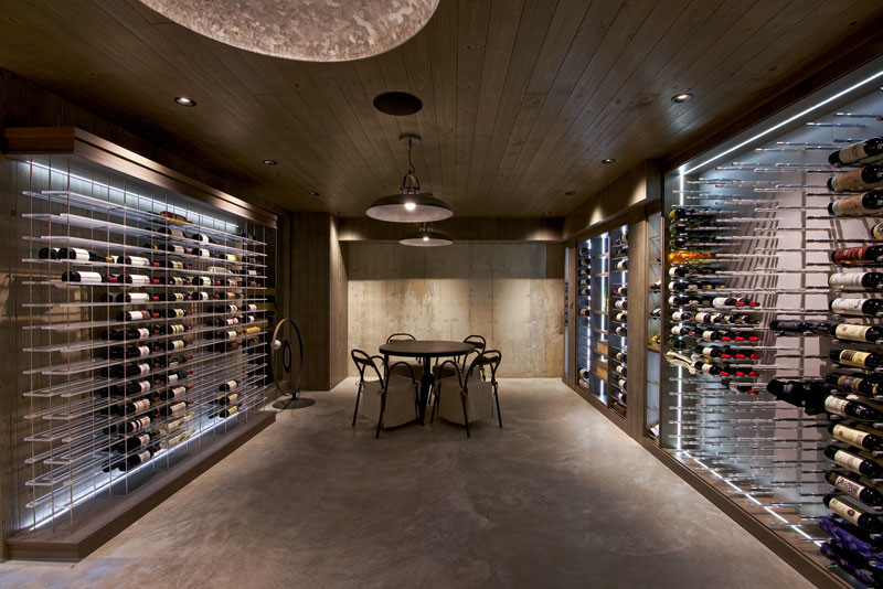 Large contemporary wine cellar in Los Angeles with concrete floors and display racks.