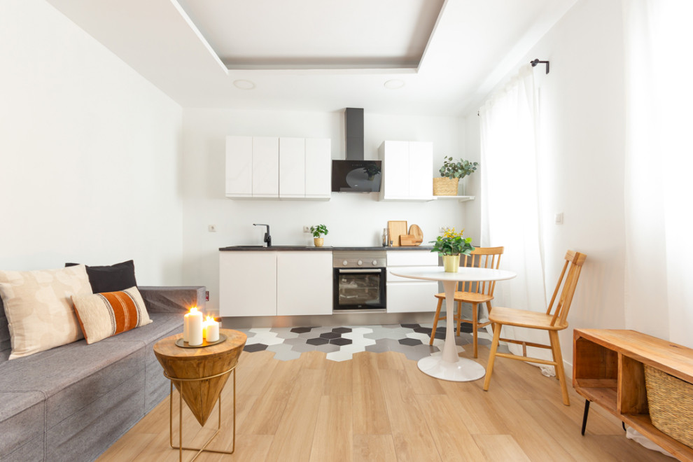 Ejemplo de sala de estar tipo loft urbana pequeña sin televisor con paredes blancas, suelo de madera en tonos medios y suelo marrón