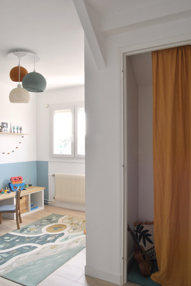 Idee per una cameretta per bambini scandinava di medie dimensioni con pareti bianche, pavimento in laminato e carta da parati