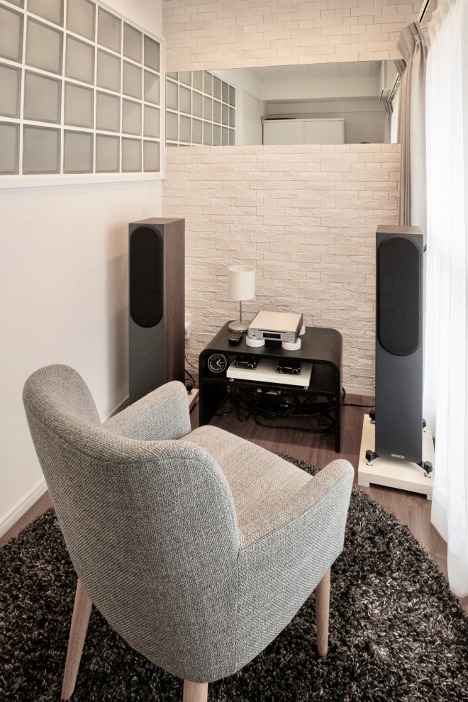 Photo of a small contemporary enclosed home theatre in Tokyo with white walls, plywood floors and brown floor.