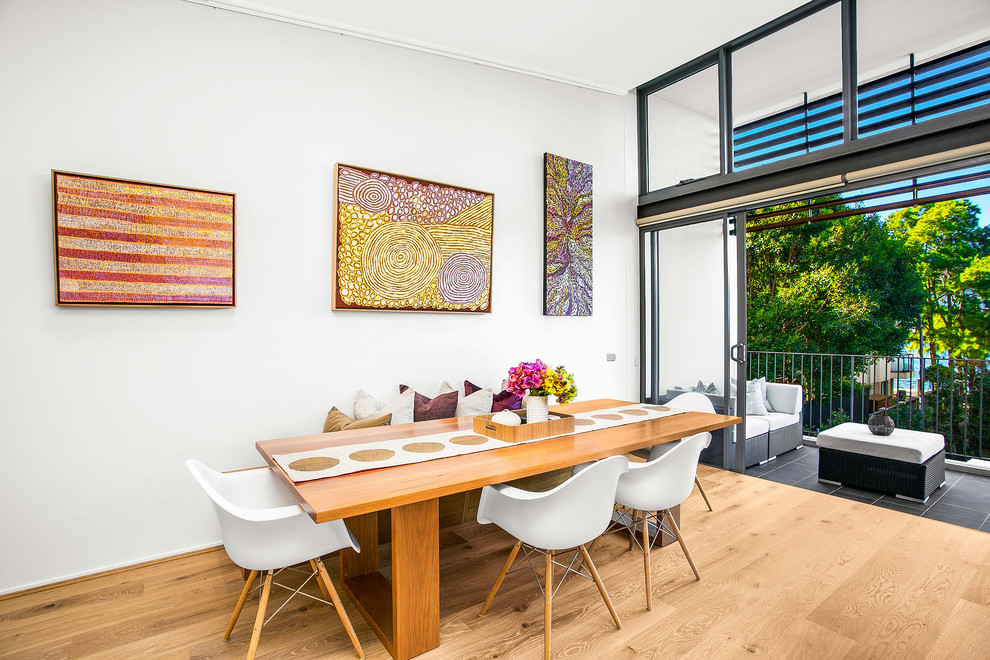 Inspiration for a contemporary dining room in Sydney with light hardwood floors and white walls.