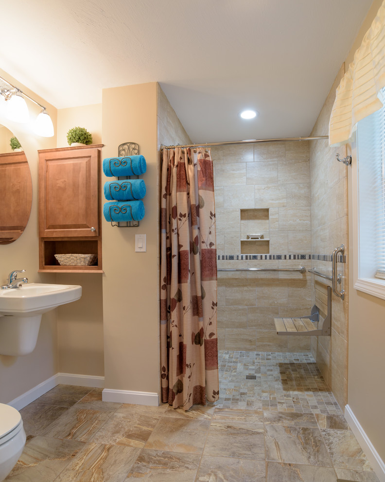 Photo of a transitional 3/4 bathroom in Boston with raised-panel cabinets, medium wood cabinets, a curbless shower, a two-piece toilet, beige tile, ceramic tile, beige walls and a wall-mount sink.