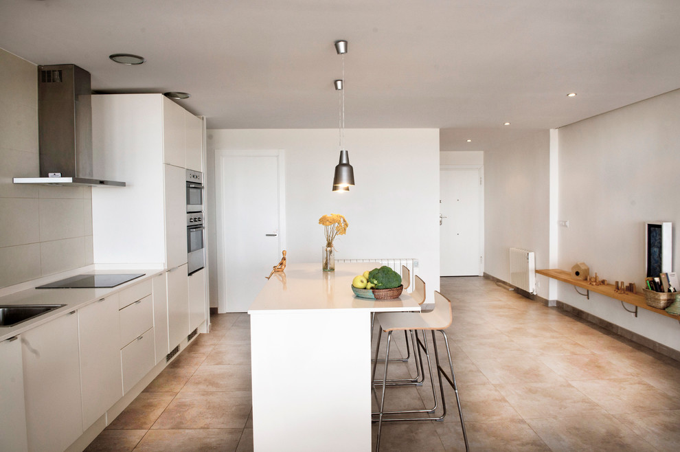 This is an example of a mid-sized contemporary single-wall eat-in kitchen in Valencia with an undermount sink, white cabinets, onyx benchtops, white splashback, stone slab splashback, stainless steel appliances, porcelain floors and with island.