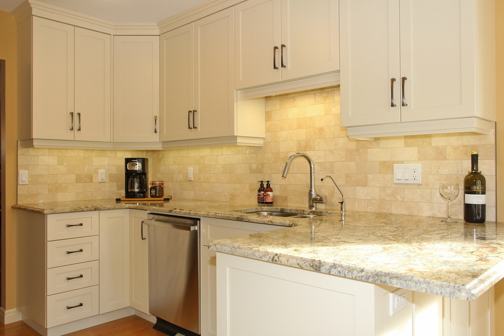 Small transitional galley medium tone wood floor and brown floor kitchen photo with an undermount sink, granite countertops, beige backsplash, stainless steel appliances, no island and shaker cabinets