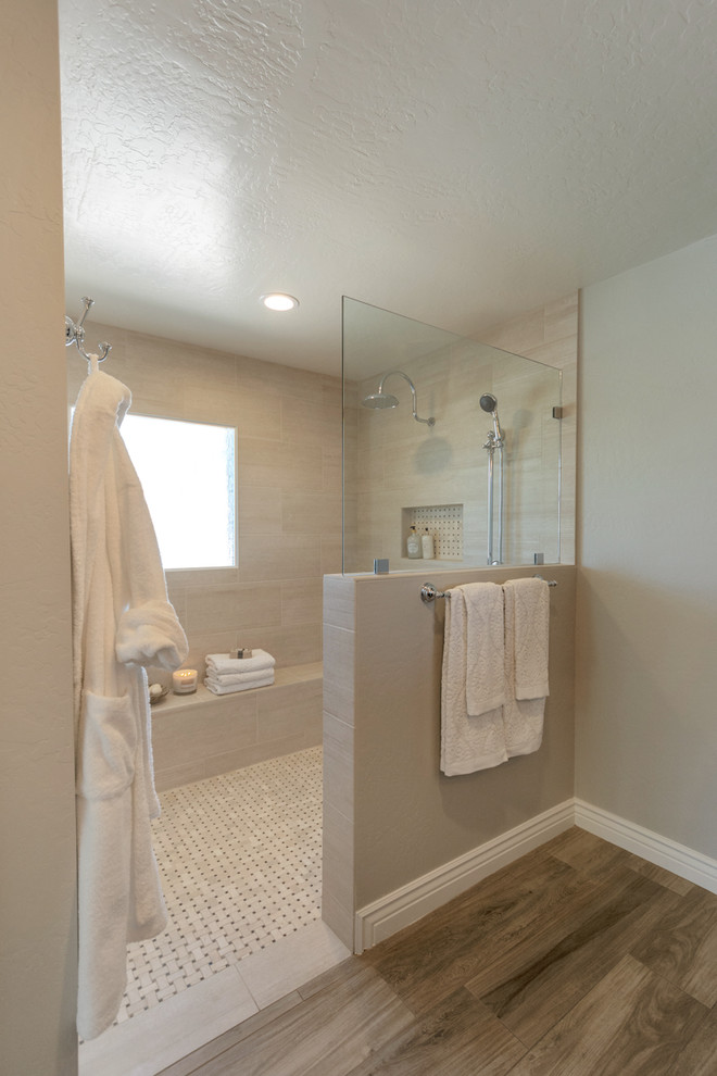 Inspiration for a mid-sized country master bathroom in Phoenix with raised-panel cabinets, black cabinets, a curbless shower, a two-piece toilet, beige tile, porcelain tile, grey walls, porcelain floors, an undermount sink, engineered quartz benchtops, brown floor, an open shower and white benchtops.