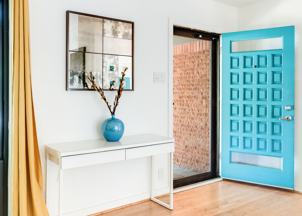 Photo of a modern front door in Denver with white walls, light hardwood floors, a single front door and a blue front door.