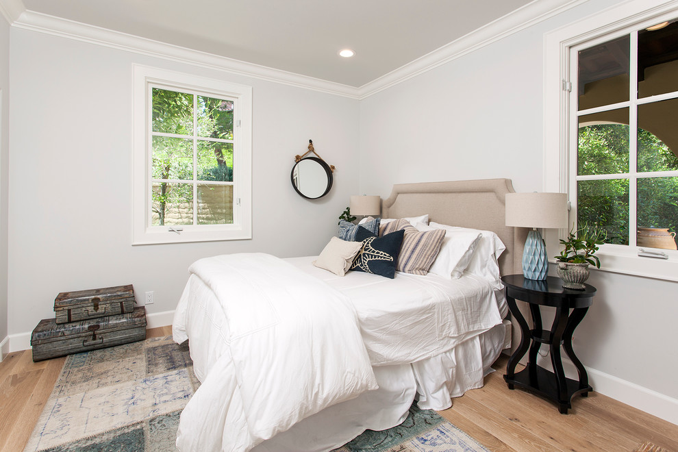 This is an example of a small beach style guest bedroom in Other with grey walls and light hardwood floors.