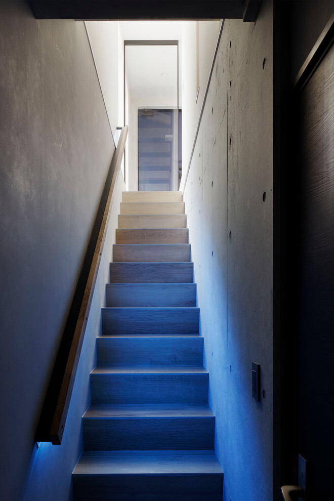 Réalisation d'un escalier carrelé droit minimaliste avec des contremarches carrelées, un garde-corps en bois et éclairage.