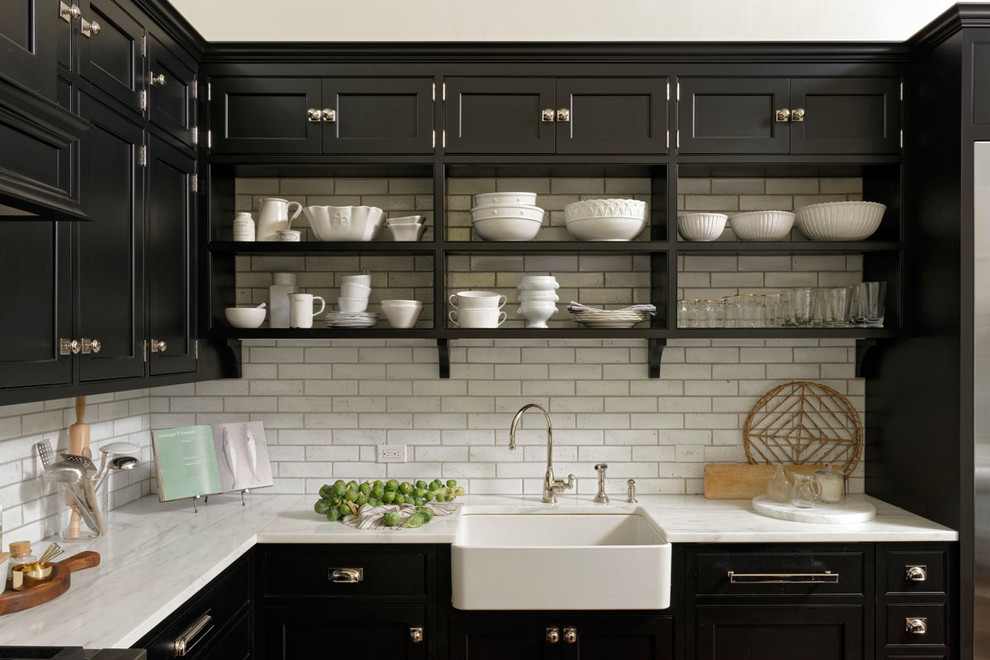 Inspiration for a large transitional l-shaped medium tone wood floor and brown floor eat-in kitchen remodel in DC Metro with a farmhouse sink, beaded inset cabinets, black cabinets, white backsplash, subway tile backsplash, stainless steel appliances, an island and quartzite countertops