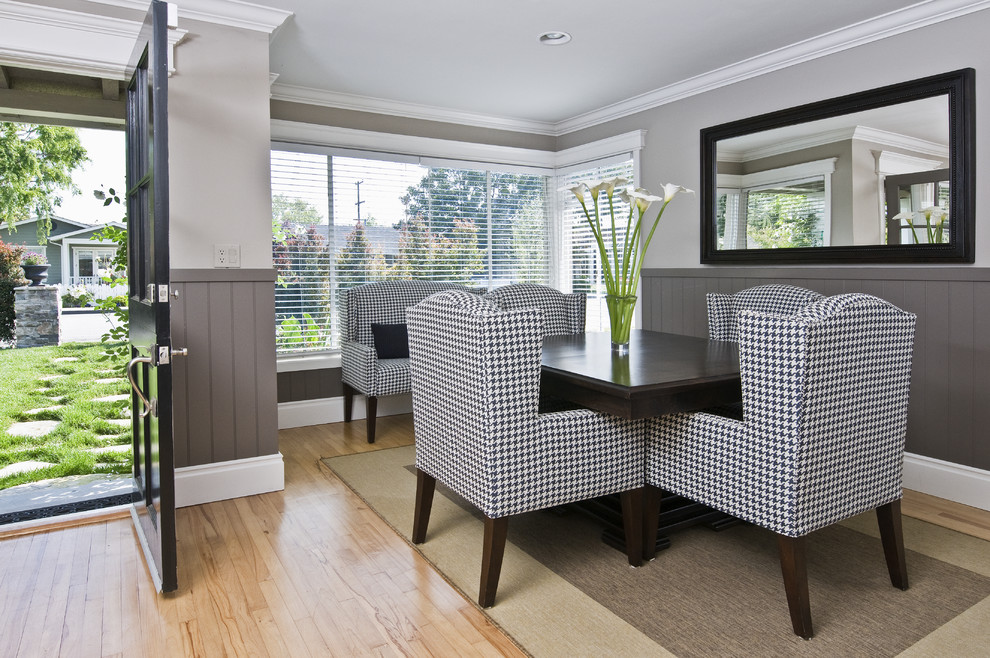 Contemporary dining room in Orange County with grey walls and light hardwood floors.