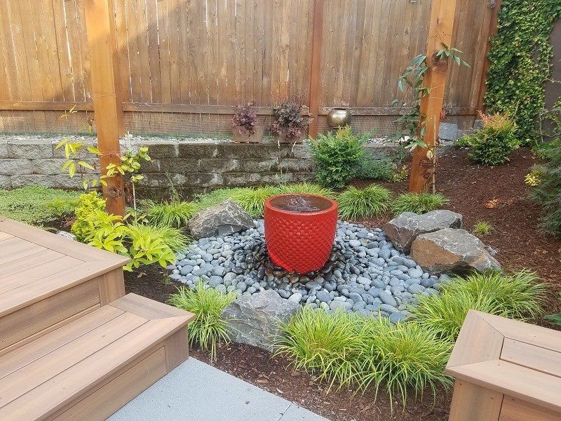 Inspiration for a small backyard concrete paver water fountain landscape in Seattle.