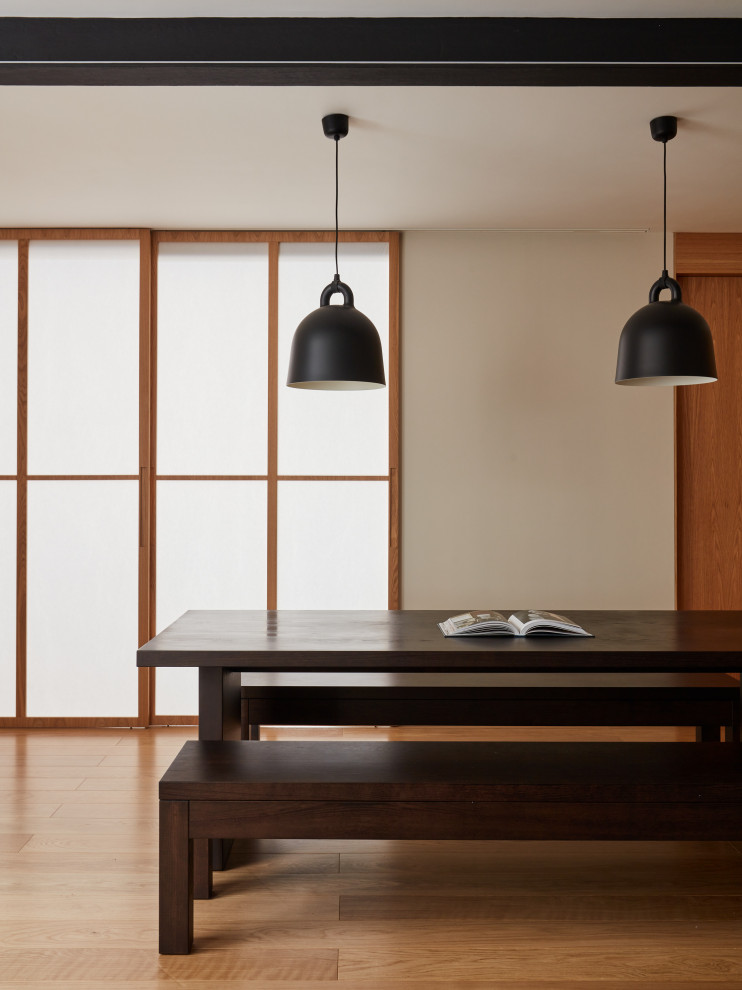 Ispirazione per una sala da pranzo aperta verso il soggiorno moderna di medie dimensioni con pareti beige e pavimento in legno massello medio