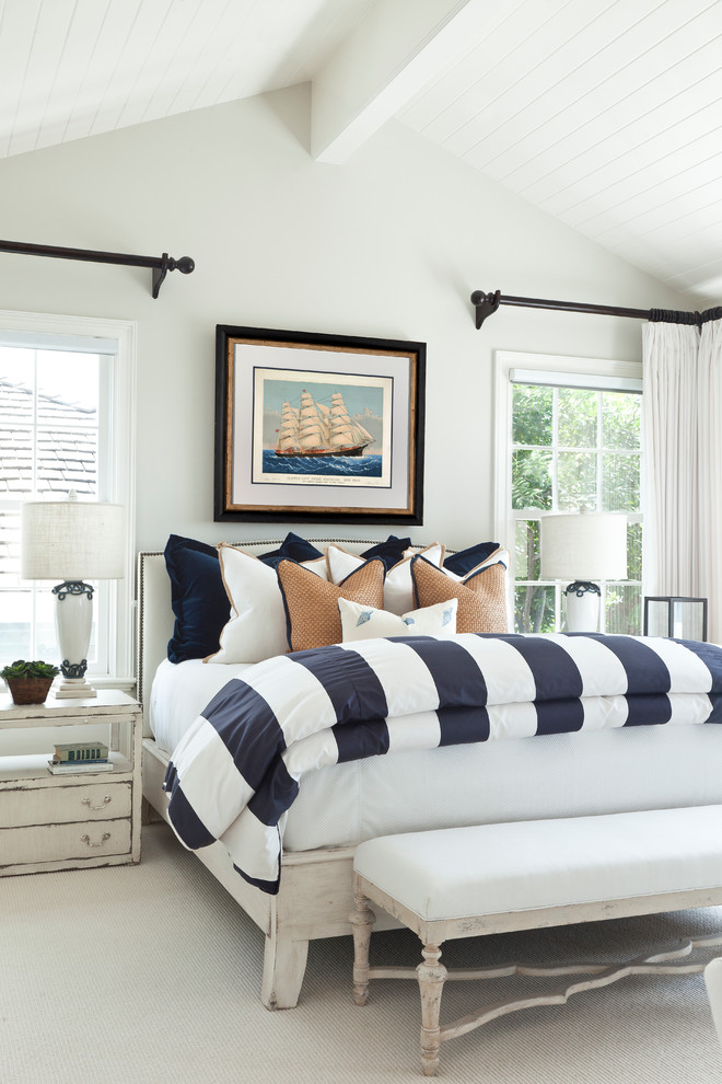 Large beach style master bedroom in Orange County with white walls and carpet.