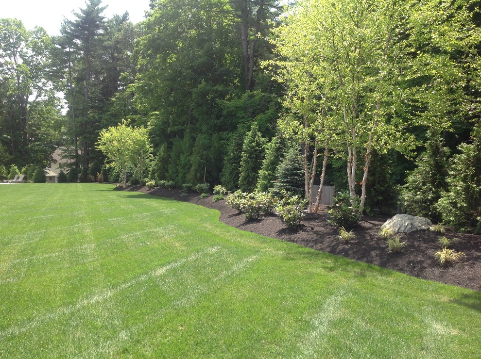This is an example of a mid-sized traditional backyard full sun formal garden in Boston with a garden path and natural stone pavers.