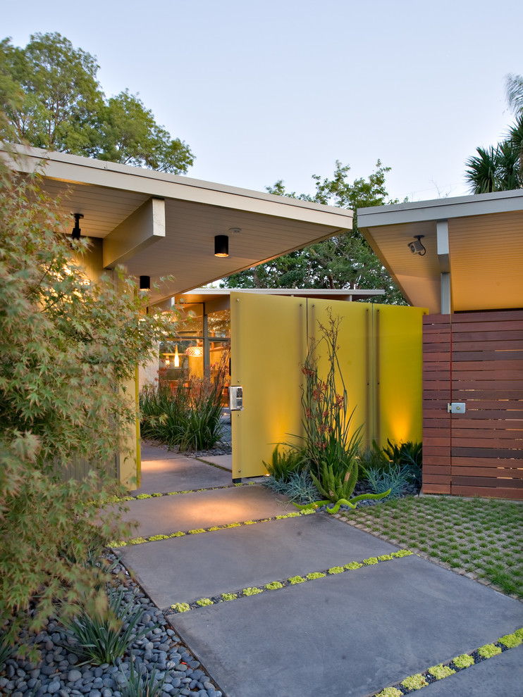 This is an example of a midcentury entryway in San Francisco with a yellow front door.