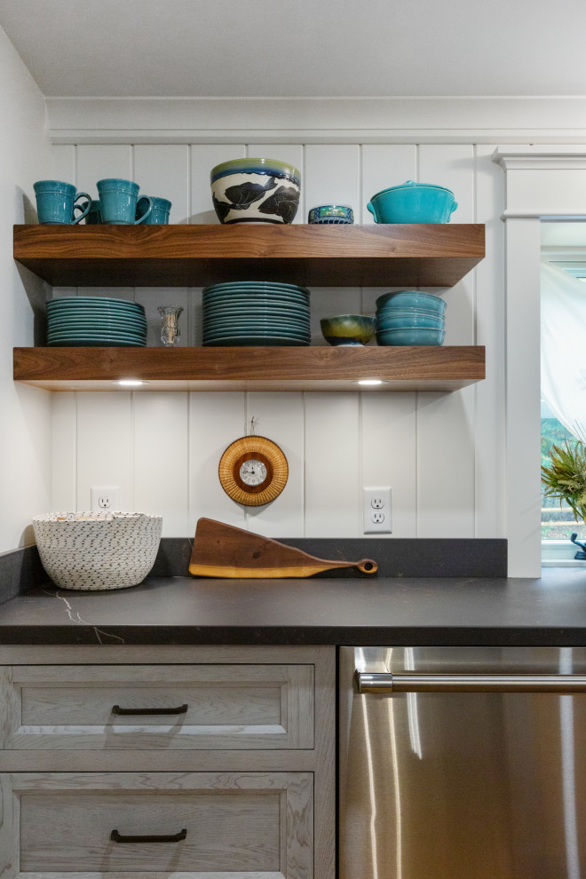 Inspiration for a mid-sized eclectic l-shaped eat-in kitchen in Boston with a farmhouse sink, flat-panel cabinets, grey cabinets, quartz benchtops, white splashback, timber splashback, stainless steel appliances, medium hardwood floors, with island, brown floor and black benchtop.