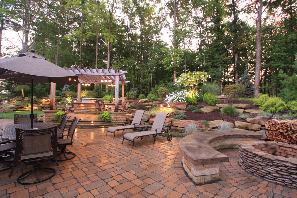 Design ideas for a mid-sized traditional backyard patio in Cleveland with a fire feature, concrete pavers and a pergola.