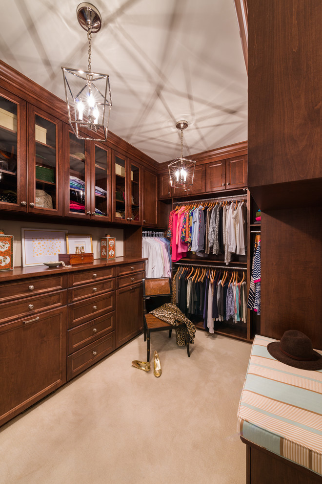 Design ideas for a small traditional gender-neutral dressing room in Charlotte with recessed-panel cabinets, medium wood cabinets, carpet and beige floor.
