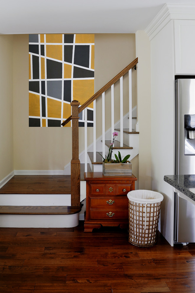 This is an example of a mid-sized transitional wood l-shaped staircase with painted wood risers and wood railing.