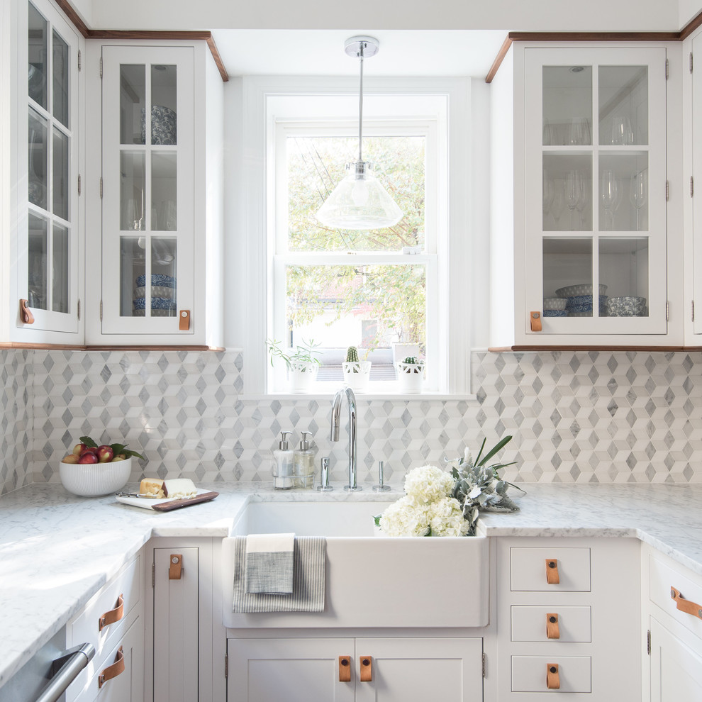 Inspiration for a small transitional u-shaped kitchen in DC Metro with a farmhouse sink, glass-front cabinets, white cabinets, grey splashback and stainless steel appliances.