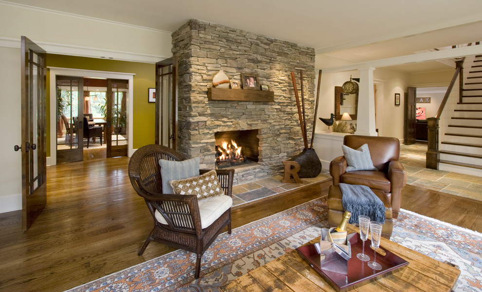 Photo of a large arts and crafts open concept living room in New York with a stone fireplace surround, beige walls, medium hardwood floors and a standard fireplace.