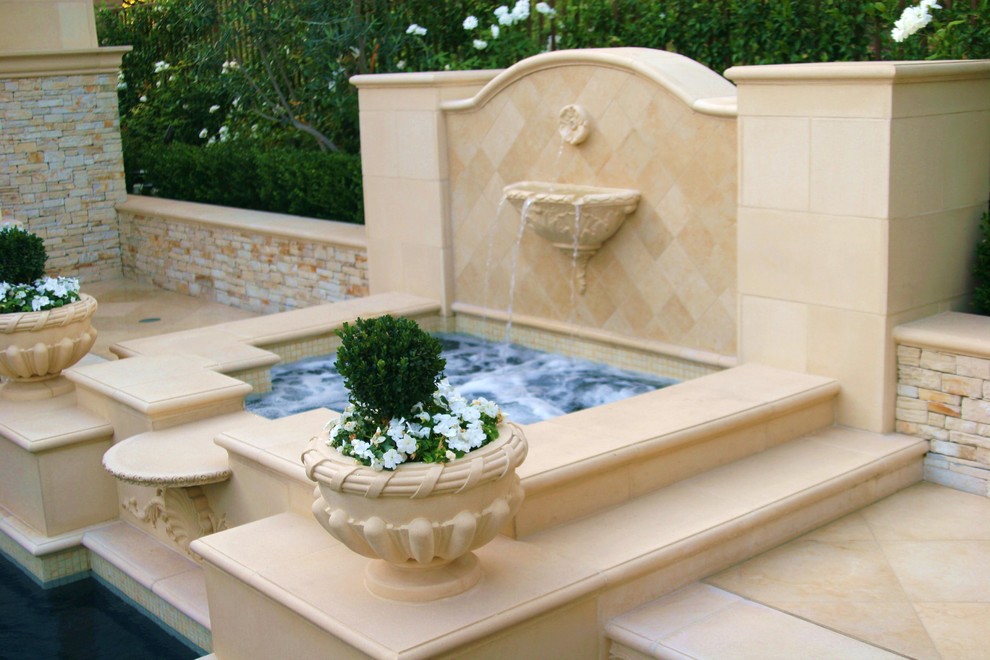 Design ideas for a small mediterranean backyard custom-shaped pool in Orange County with a water feature and concrete pavers.
