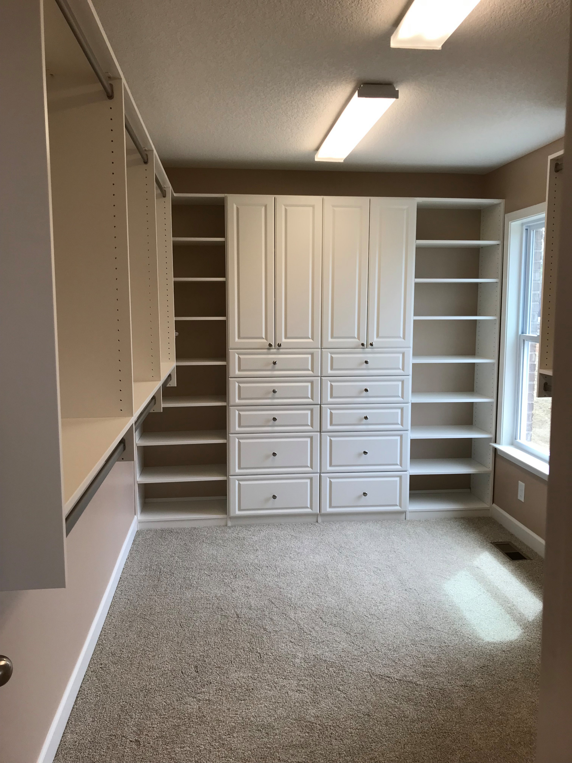 Primary Closet with Raised Panel Cabinets and Drawers