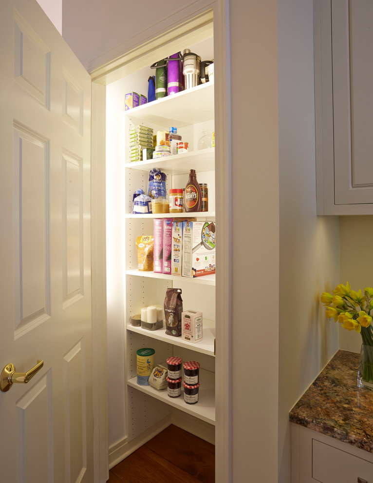 Enclosed kitchen - mid-sized transitional u-shaped medium tone wood floor enclosed kitchen idea in Chicago with a single-bowl sink, raised-panel cabinets, white cabinets, granite countertops, white backsplash, glass tile backsplash, stainless steel appliances and an island