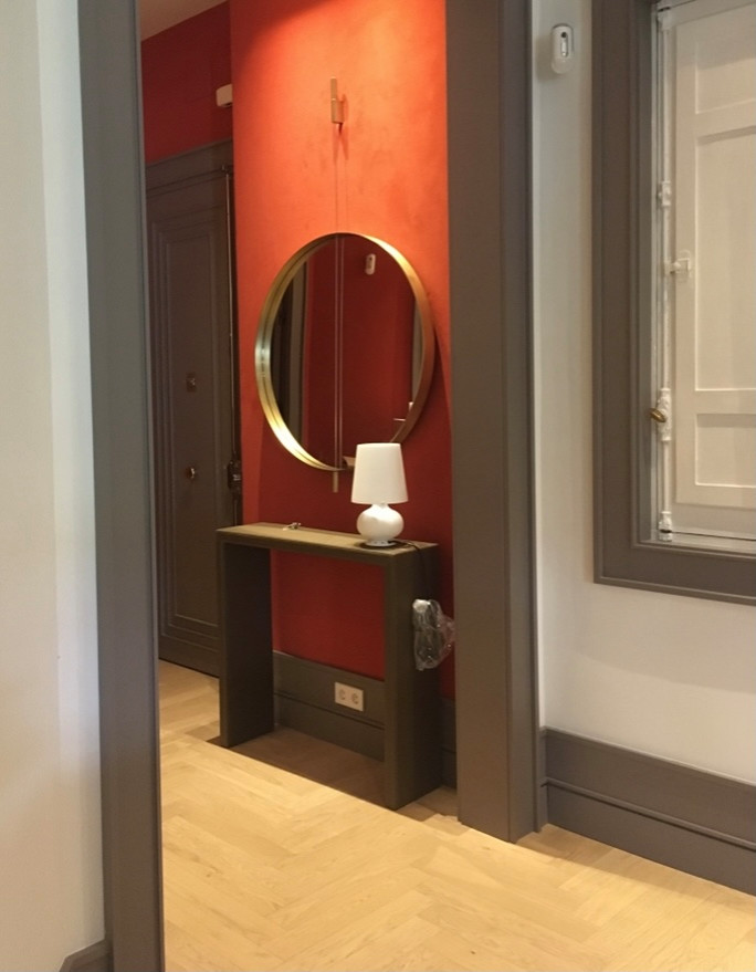 Imagen de entrada tradicional renovada de tamaño medio con paredes rojas y suelo de madera clara