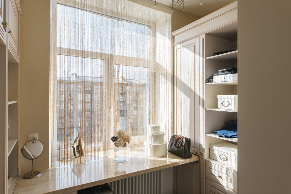 Inspiration for a mid-sized traditional walk-in wardrobe in Saint Petersburg with raised-panel cabinets, light wood cabinets, light hardwood floors and beige floor.