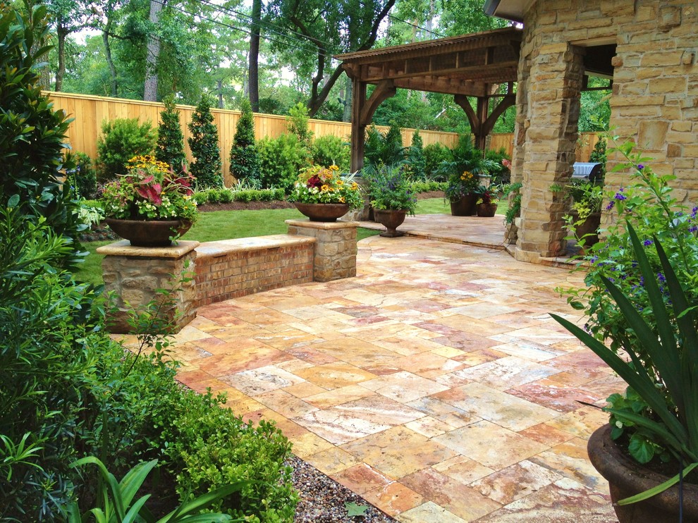 Inspiration for a large traditional courtyard partial sun formal garden for summer in Houston with a garden path and natural stone pavers.