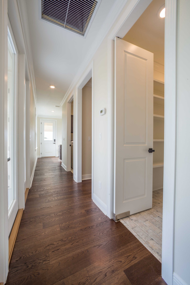 Example of a mid-sized classic medium tone wood floor and brown floor hallway design with beige walls