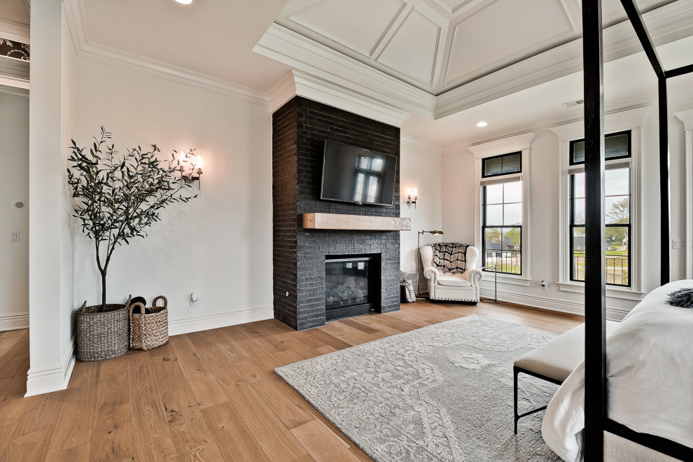 Inspiration for a large transitional master light wood floor and vaulted ceiling bedroom remodel in Other with white walls, a standard fireplace and a brick fireplace