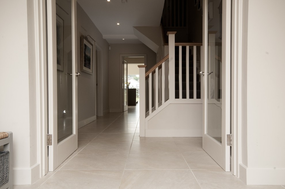 Photo of a mid-sized contemporary hallway in Dublin with white walls and porcelain floors.