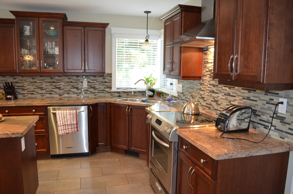 Mid-sized transitional l-shaped limestone floor eat-in kitchen photo in Vancouver with a double-bowl sink, recessed-panel cabinets, medium tone wood cabinets, granite countertops, gray backsplash, matchstick tile backsplash, stainless steel appliances and an island