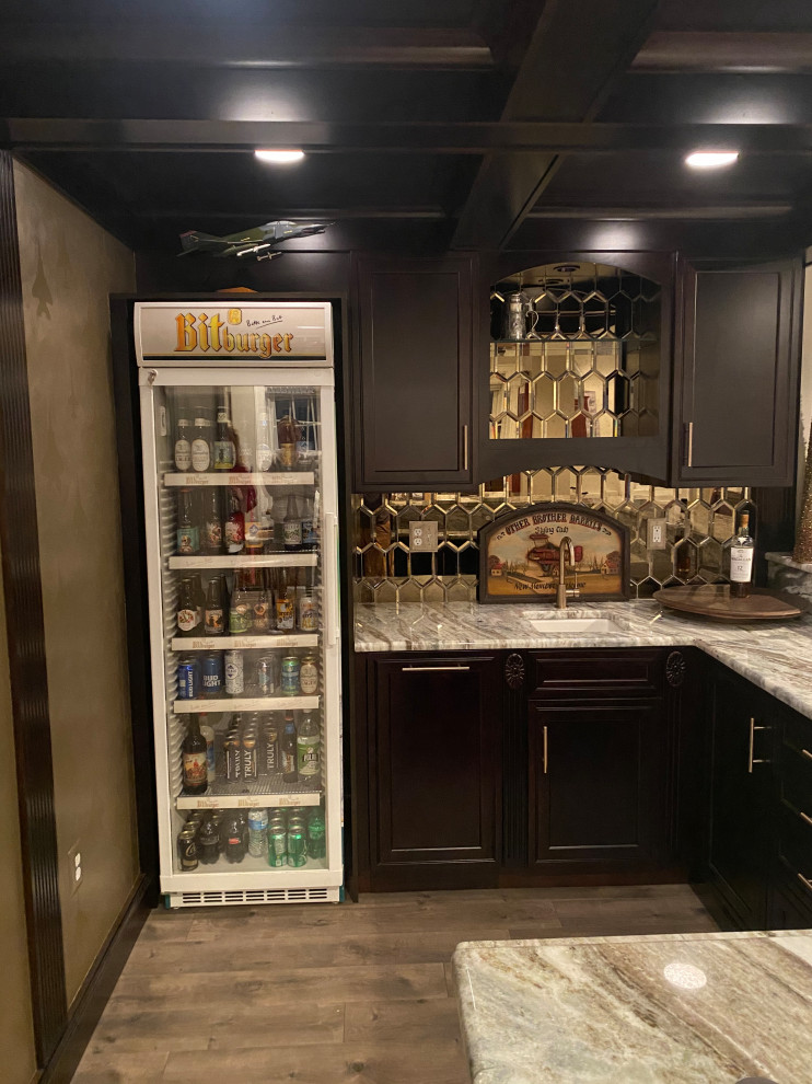 Photo of an u-shaped wet bar in DC Metro with an undermount sink, flat-panel cabinets, brown cabinets, granite benchtops, mirror splashback, laminate floors, brown floor and multi-coloured benchtop.