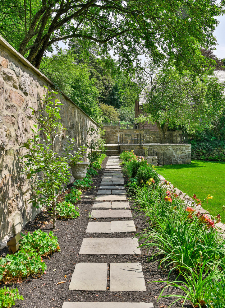 Design ideas for a mid-sized traditional backyard partial sun garden in Boston with a garden path, natural stone pavers and a stone fence.