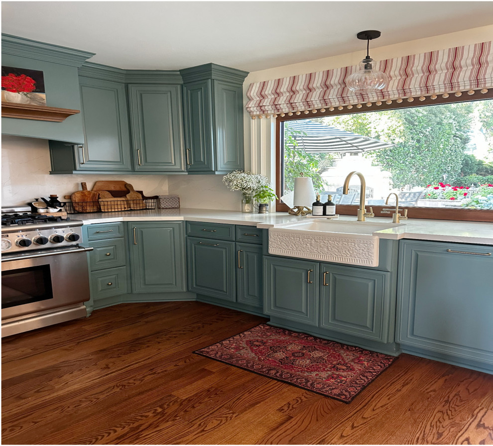 Idéer för mellanstora vintage vitt kök, med en rustik diskho, luckor med upphöjd panel, gröna skåp, bänkskiva i koppar, vitt stänkskydd, färgglada vitvaror, mellanmörkt trägolv, en köksö och brunt golv