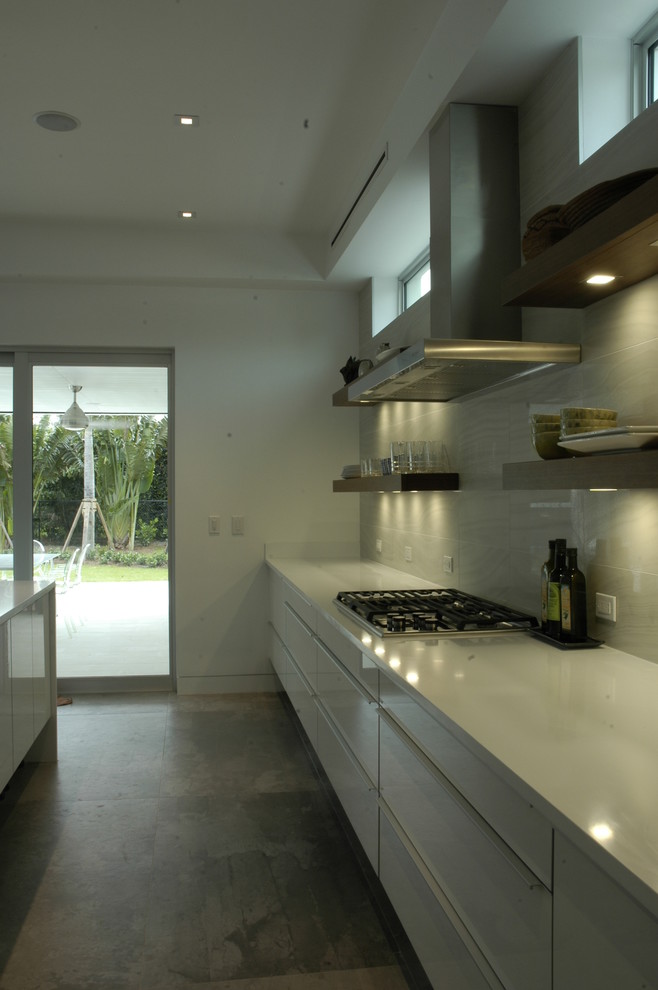 Design ideas for a mid-sized modern galley eat-in kitchen in Miami with an undermount sink, open cabinets, white cabinets, quartzite benchtops, white splashback, cement tile splashback, white appliances, porcelain floors and with island.