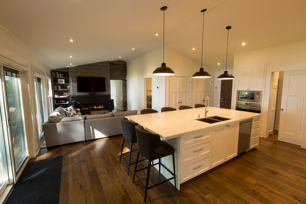 Design ideas for a contemporary u-shaped open plan kitchen in Other with an undermount sink, shaker cabinets, white cabinets, quartzite benchtops, white splashback, marble splashback, stainless steel appliances, medium hardwood floors, with island and white benchtop.