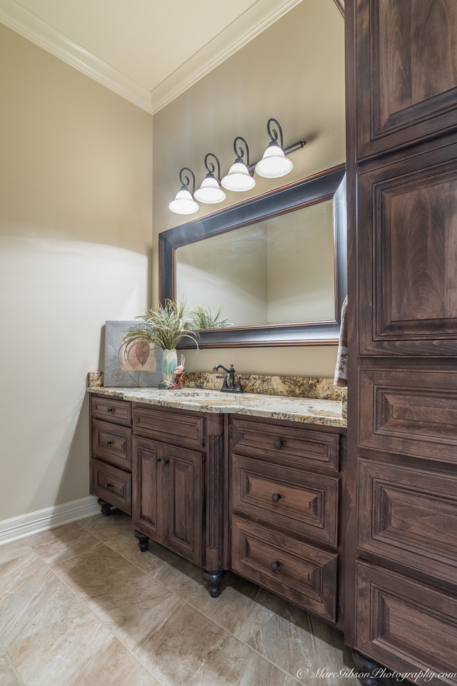 Large country master bathroom in New Orleans with raised-panel cabinets, medium wood cabinets, a corner tub, an alcove shower, a two-piece toilet, stone tile, beige walls, brick floors, an undermount sink and granite benchtops.