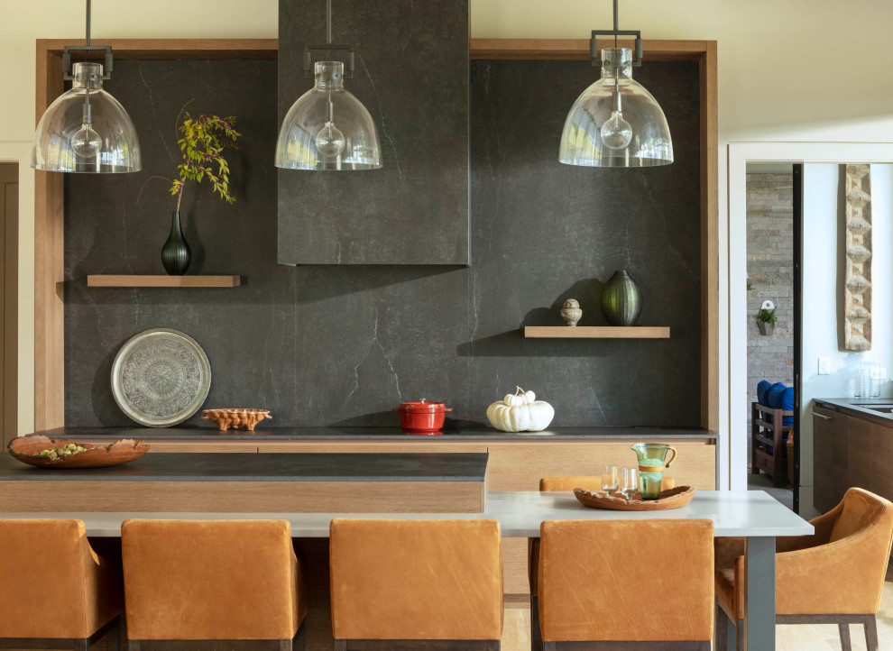 Mittelgroße Moderne Wohnküche in L-Form mit Granit-Arbeitsplatte, Küchenrückwand in Schwarz, Rückwand aus Granit, hellem Holzboden, Kücheninsel, braunem Boden, schwarzer Arbeitsplatte und gewölbter Decke in Baltimore