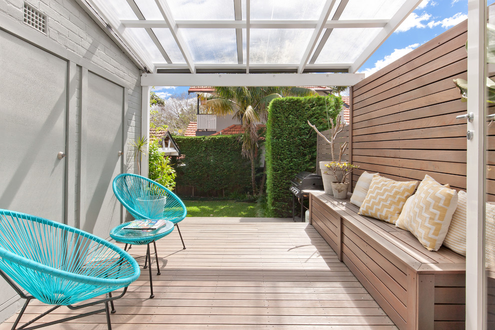 Mid-sized scandinavian backyard deck in Other with a pergola.