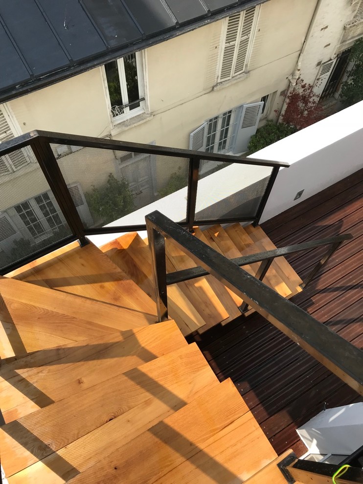 Photo of a small industrial wood l-shaped staircase in Paris with open risers and metal railing.